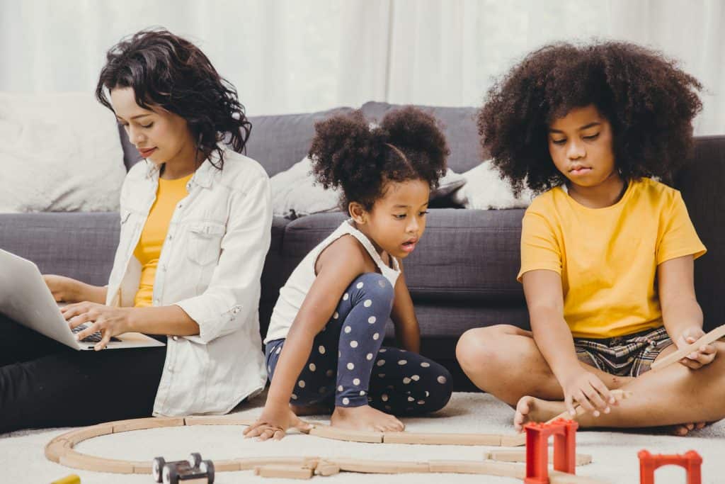 Family enjoying quality time with children playing with train set at home.